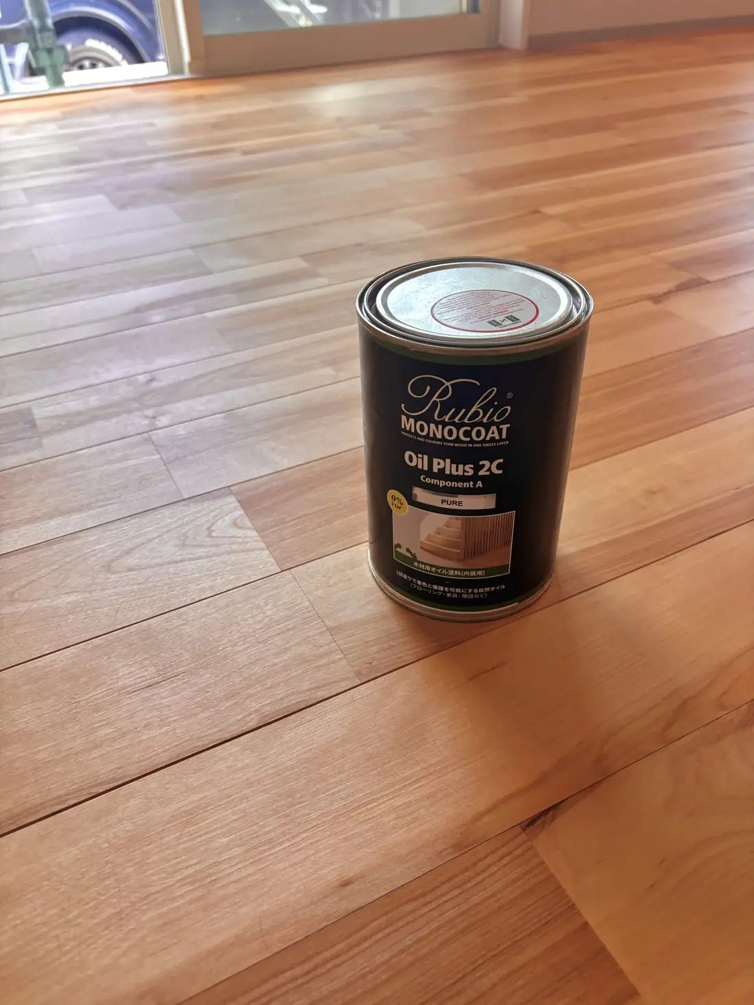 仕上げに使った Rubio Monocoat Oil Plus 2C の缶と施工後の無垢フローリング